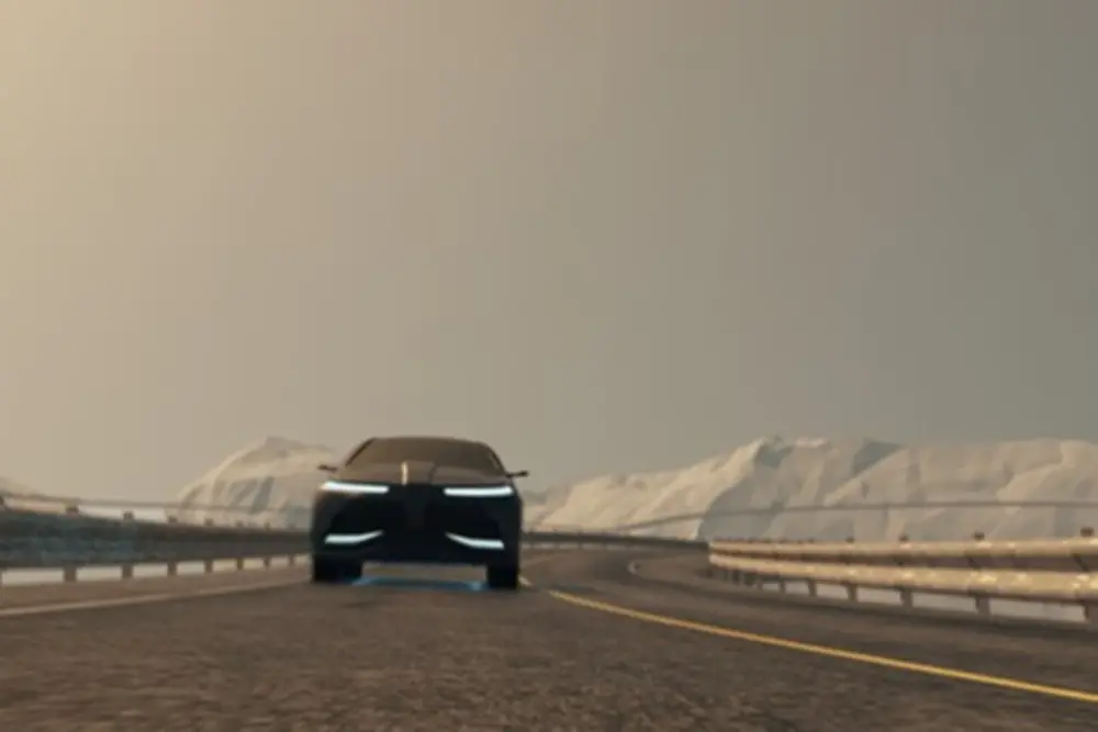 Coche que es conducido en una calle con montañas nevadas en la parte posterior.